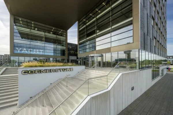 Moderne kantoorgebouw Cornerstone aan het Airportplein in Rotterdam met glazen gevel en trapopgang.
